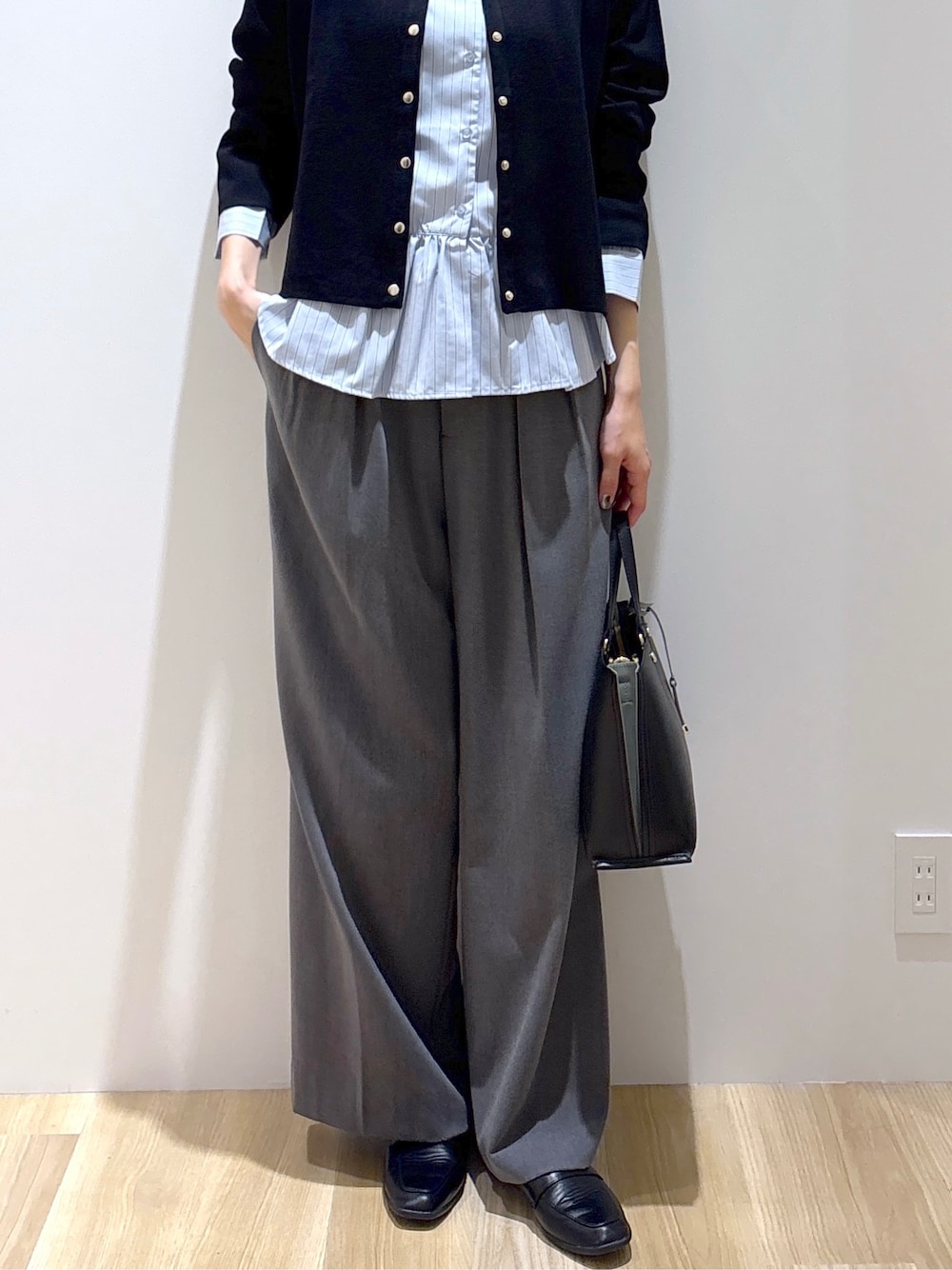 ブラック系のカーディガン/ボレロ、ブルー系のシャツ/ブラウス、グレー系のその他パンツを着用したレディースの秋コーディネートの7枚目の写真
