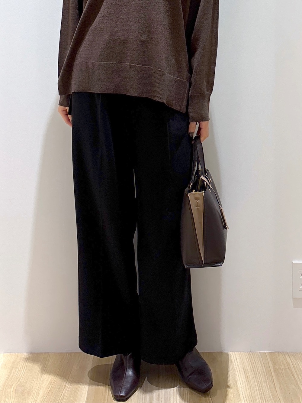 ブラウン系のニット/セーター、ブラック系のその他パンツ、ブラウン系のトートバッグを着用したレディースの秋コーディネートの7枚目の写真
