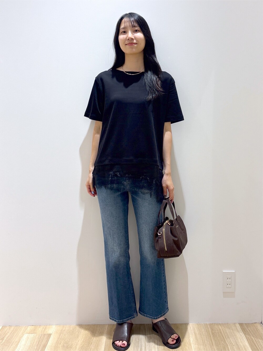 ブラック系のTシャツ/カットソー、ブルー系のデニムパンツ、ブラウン系のボストンバッグを着用したレディースの夏コーディネートの10枚目の写真