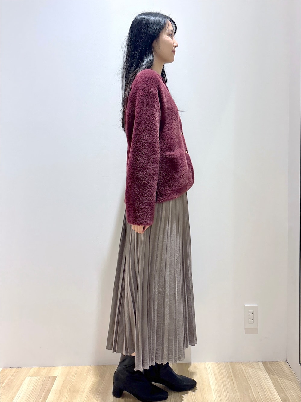 レッド系のカーディガン/ボレロ、ブラウン系のスカート、ブラック系のトートバッグを着用したレディースの秋コーディネートの5枚目の写真