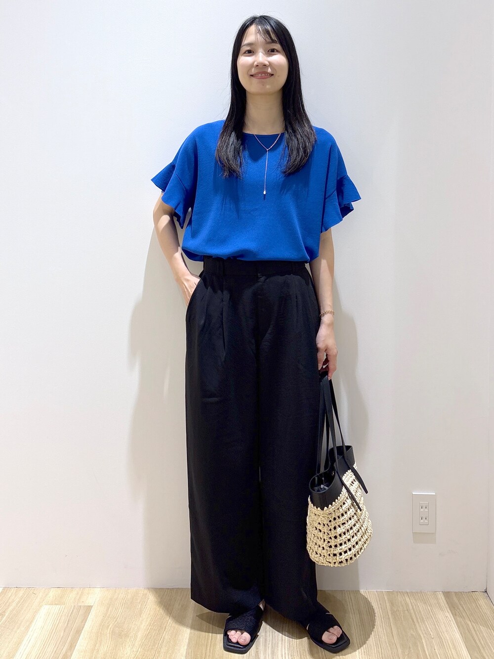 ブルー系のニット/セーター、ブラック系のその他パンツ、ブラック系のトートバッグを着用したレディースの夏コーディネートの10枚目の写真