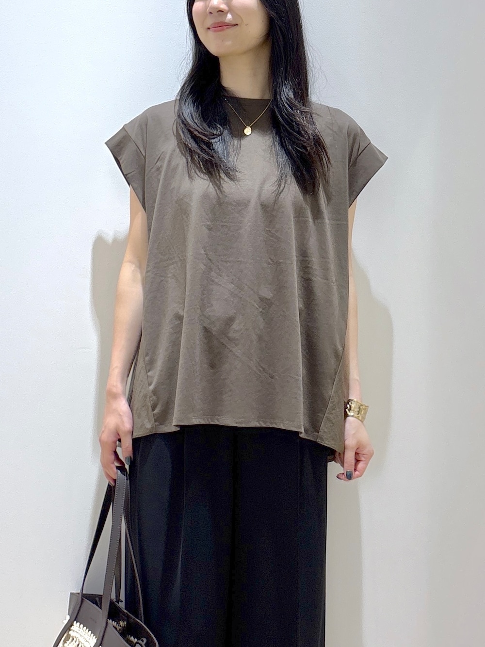 ブラウン系のTシャツ/カットソー、ブラック系のその他パンツ、ブラウン系のトートバッグを着用したレディースの夏コーディネートの6枚目の写真