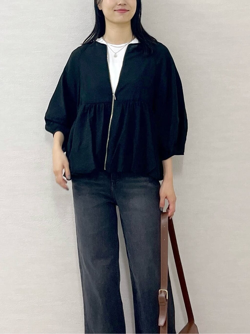 ブラック系のブルゾン、ホワイト系のTシャツ/カットソー、ブラック系のデニムパンツを着用したレディースの夏コーディネートの7枚目の写真
