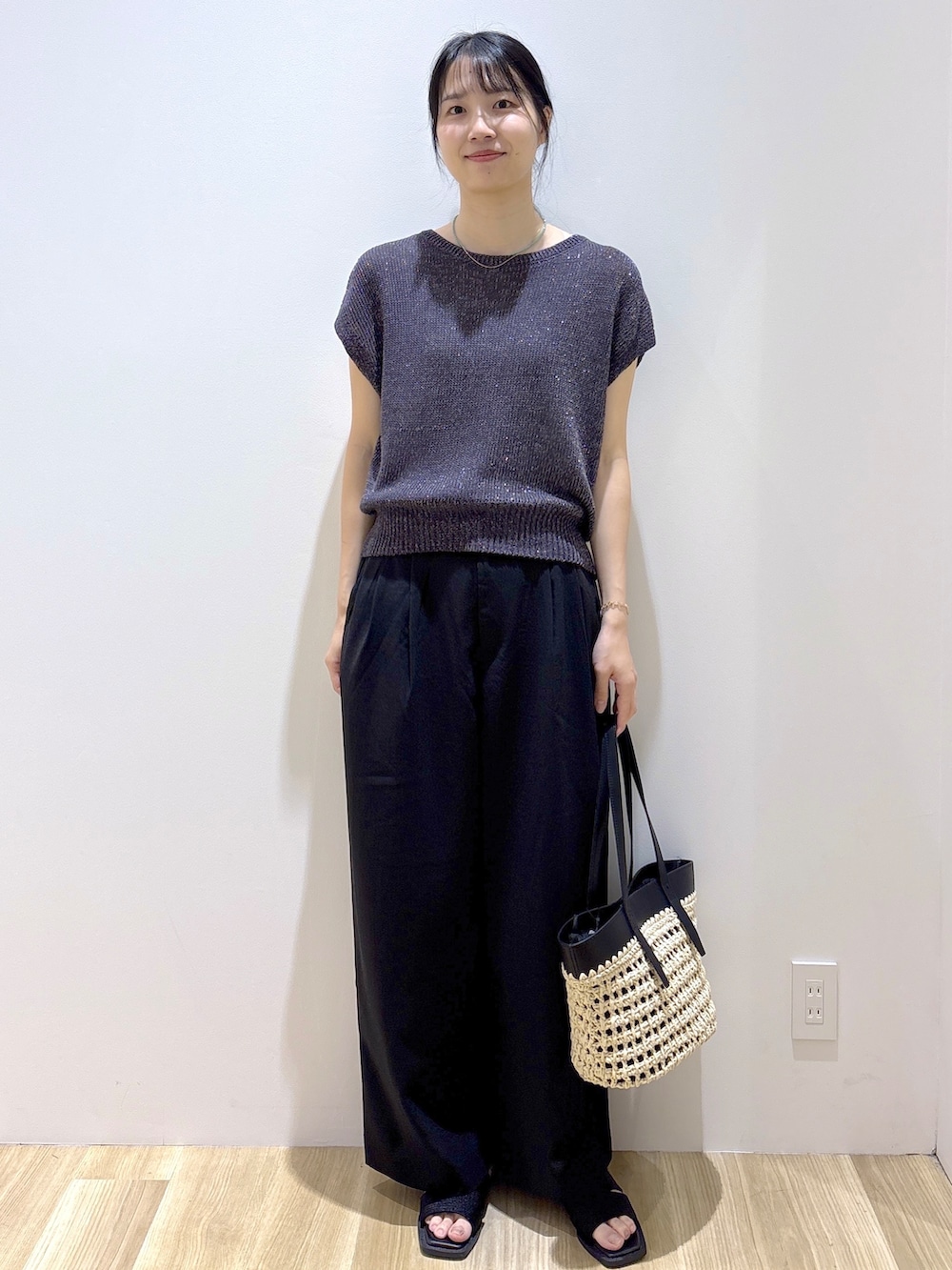 グレー系のニット/セーター、ブラック系のその他パンツ、ブラック系のトートバッグを着用したレディースの夏コーディネートの2枚目の写真