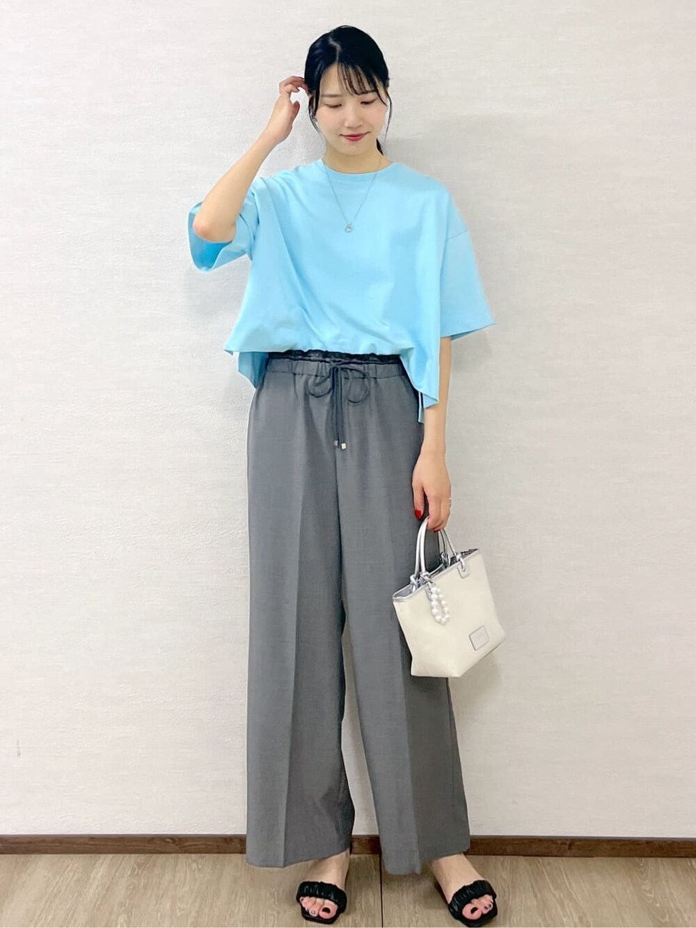 ブルー系のTシャツ/カットソー、グレー系のその他パンツ、シルバー系のトートバッグを着用したレディースの夏コーディネートの3枚目の写真