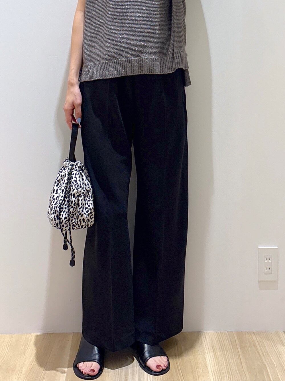 グレー系のニット/セーター、ブラック系のその他パンツ、ベージュ系のショルダーバッグを着用したレディースの夏コーディネートの7枚目の写真