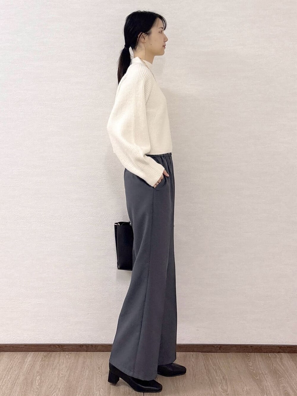 ホワイト系のニット/セーター、グレー系のその他パンツ、ブラック系のトートバッグを着用したレディースの冬コーディネートの5枚目の写真