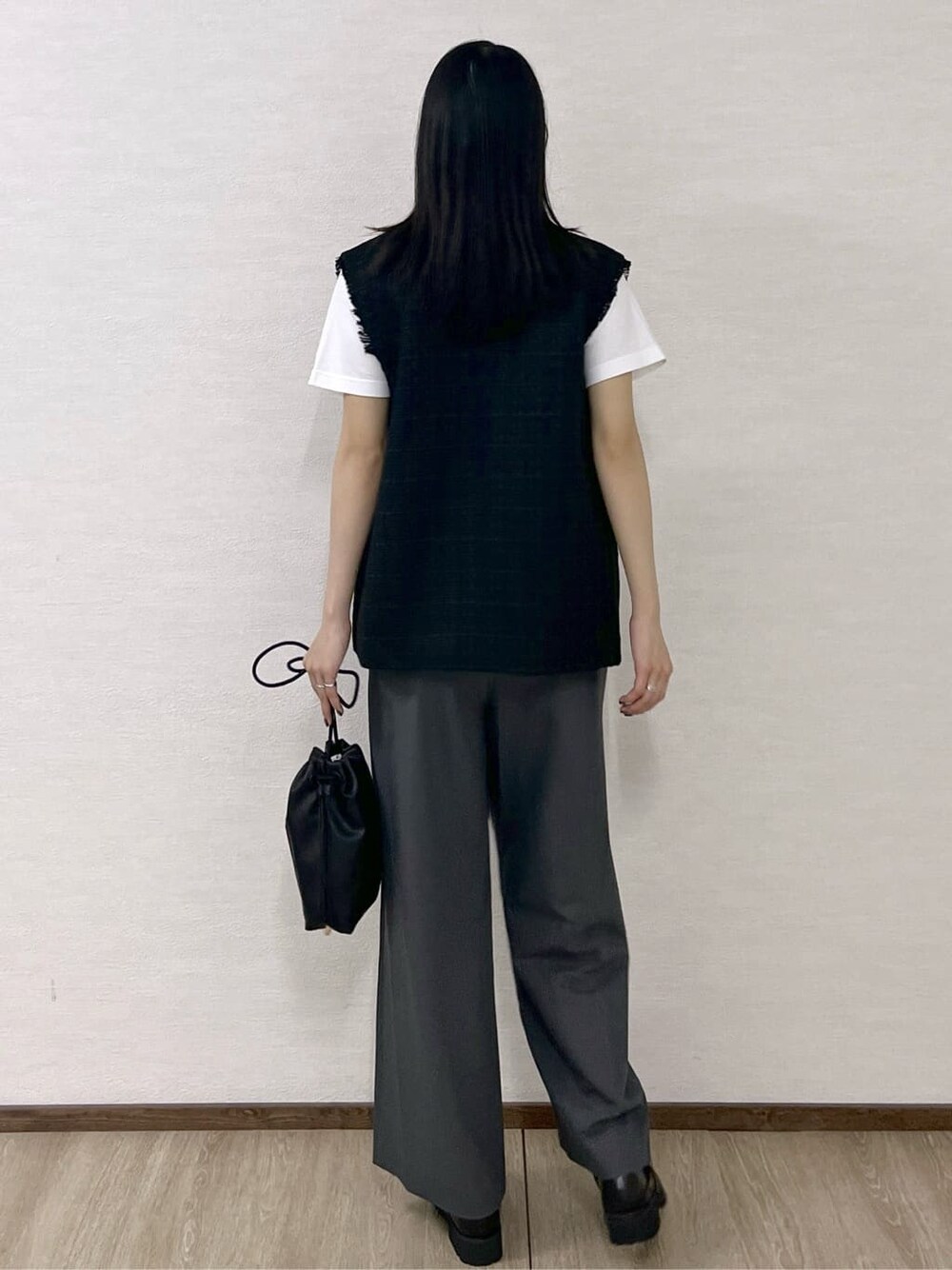 ブラック系のベスト、ホワイト系のTシャツ/カットソー、グレー系のその他パンツを着用したレディースの秋コーディネートの4枚目の写真