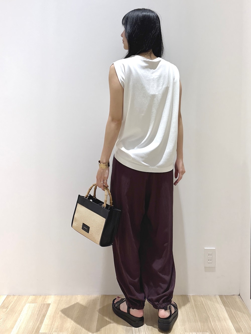 ホワイト系のTシャツ/カットソー、ブラウン系のその他パンツ、ブラック系のトートバッグを着用したレディースの夏コーディネートの4枚目の写真