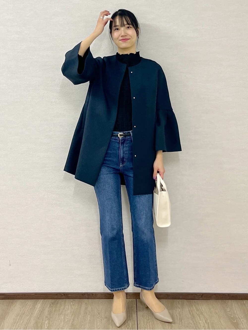 ブルー系のノーカラーコート、ブラック系のTシャツ/カットソー、ブルー系のデニムパンツを着用したレディースの冬コーディネートの10枚目の写真