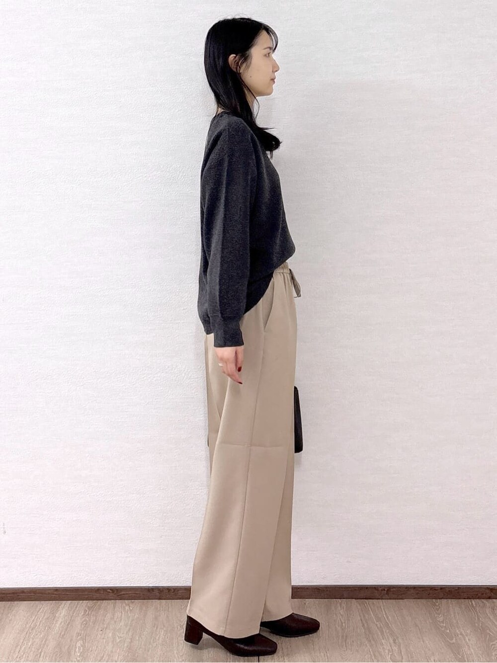グレー系のニット/セーター、ベージュ系のその他パンツ、ブラック系のトートバッグを着用したレディースの冬コーディネートの5枚目の写真