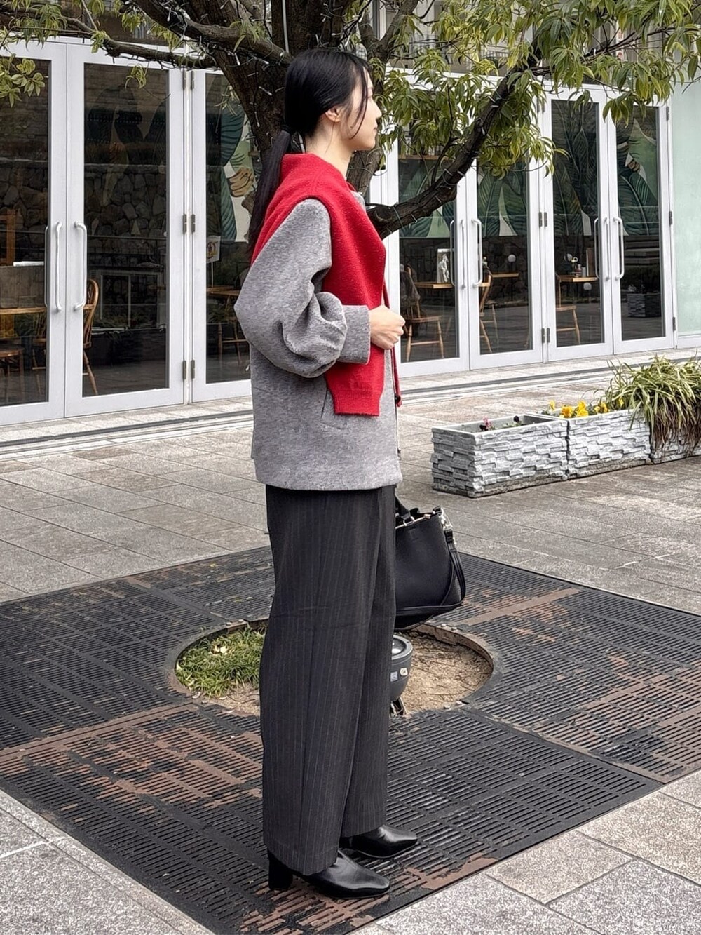 グレー系のノーカラーコート、ブラック系のニット/セーター、グレー系のその他パンツを着用したレディースの冬コーディネートの7枚目の写真