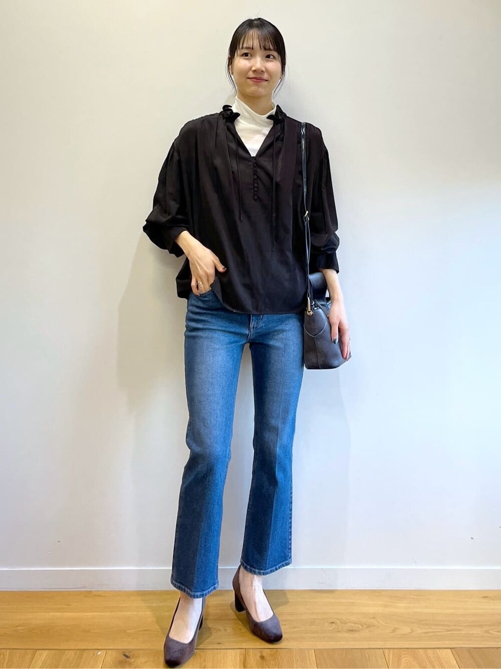 ブラック系のシャツ/ブラウス、ブルー系のデニムパンツ、グレー系のショルダーバッグを着用したレディースの冬コーディネートの10枚目の写真