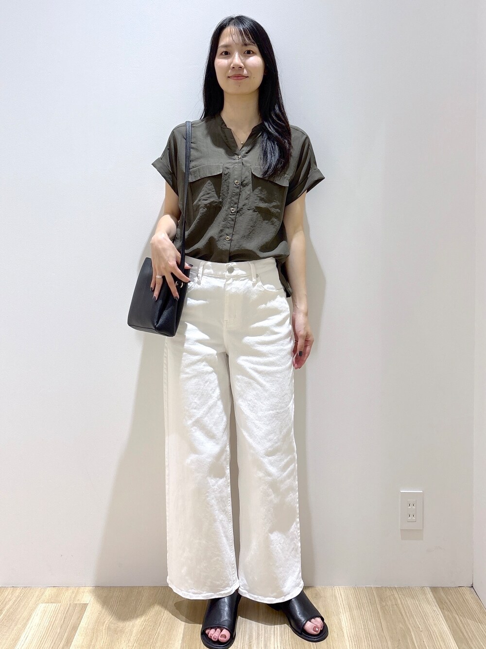 グリーン系のシャツ/ブラウス、ホワイト系のデニムパンツ、ブラック系のショルダーバッグを着用したレディースの夏コーディネートの7枚目の写真