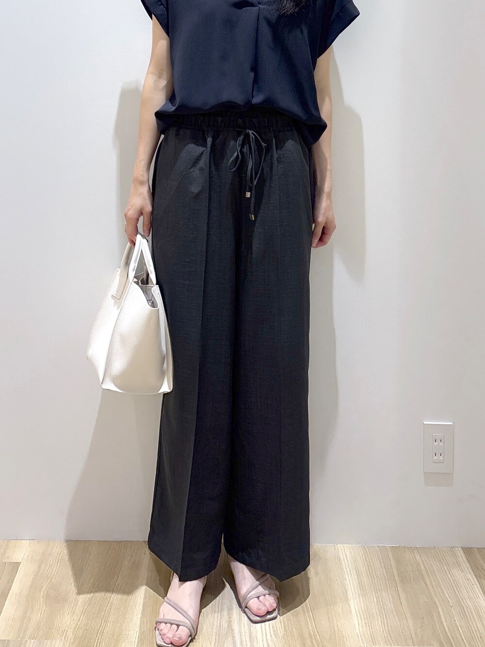 ブラック系のシャツ/ブラウス、グレー系のその他パンツ、ホワイト系のショルダーバッグを着用したレディースの夏コーディネートの7枚目の写真