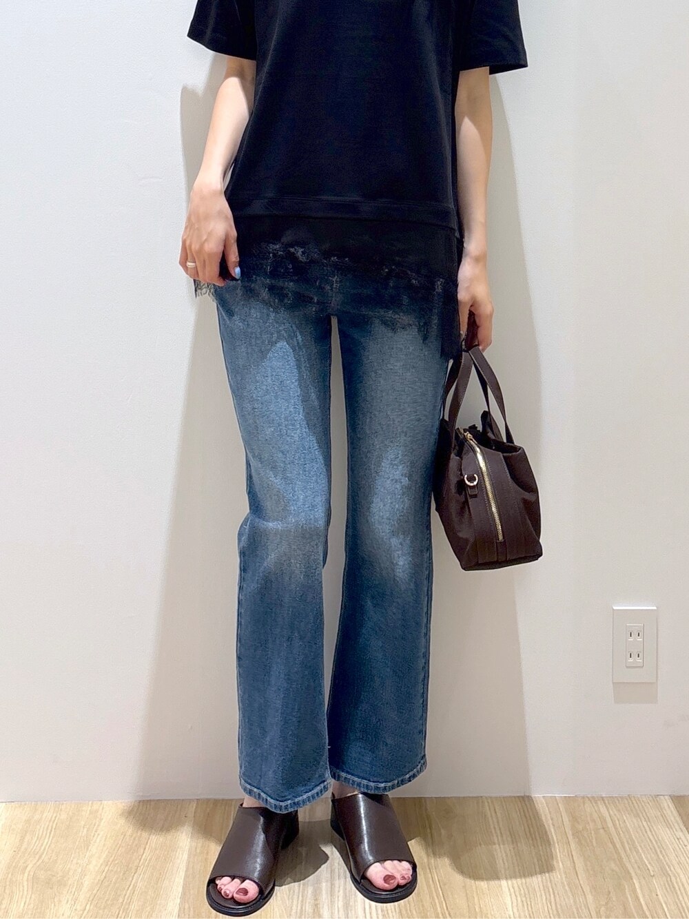 ブラック系のTシャツ/カットソー、ブルー系のデニムパンツ、ブラウン系のボストンバッグを着用したレディースの夏コーディネートの7枚目の写真