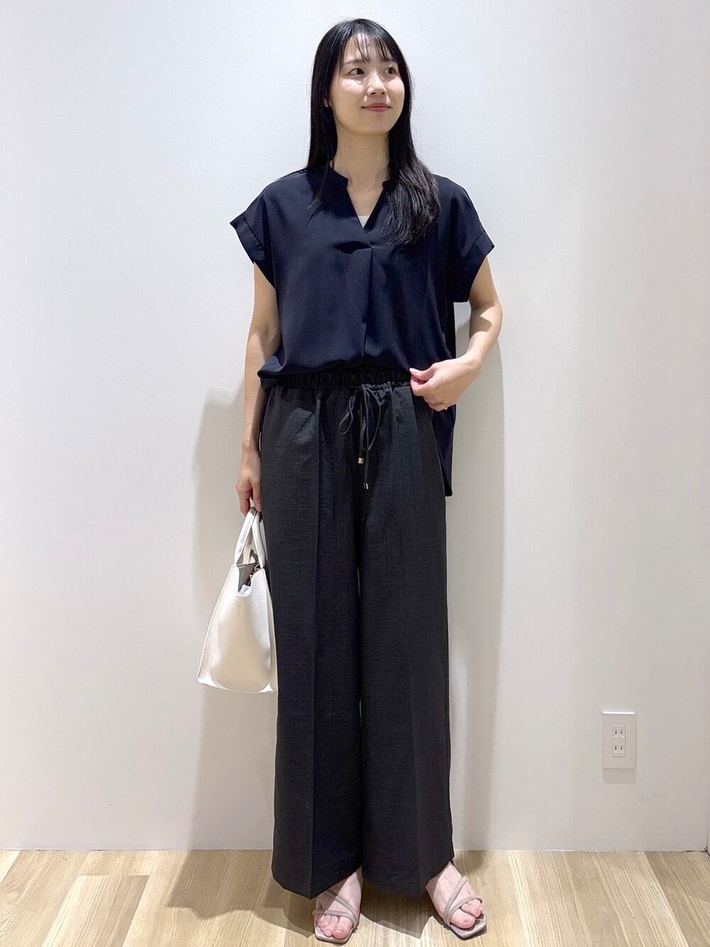 ブラック系のシャツ/ブラウス、グレー系のその他パンツ、ホワイト系のショルダーバッグを着用したレディースの夏コーディネートの2枚目の写真