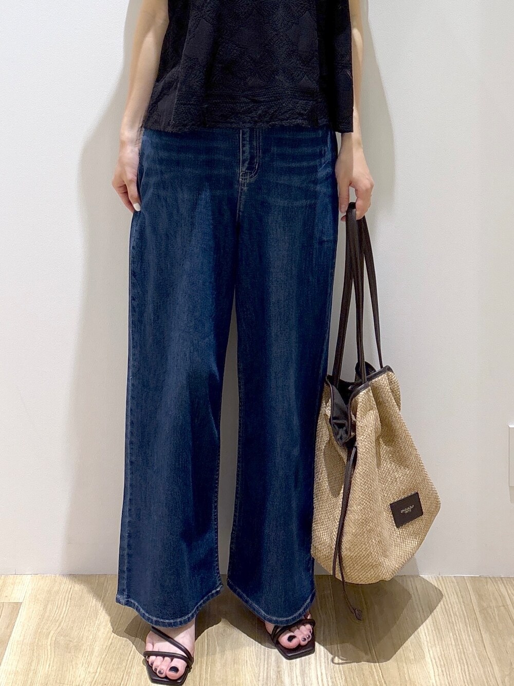 ブラック系のシャツ/ブラウス、ブルー系のデニムパンツ、ベージュ系のトートバッグを着用したレディースの春コーディネートの7枚目の写真