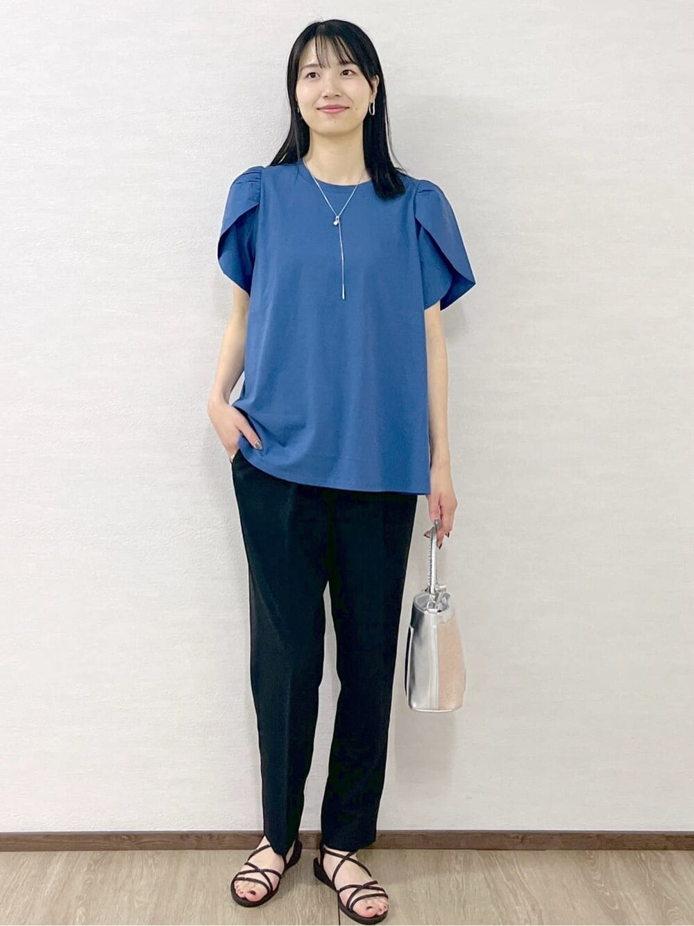 ブルー系のTシャツ/カットソー、ブラック系のその他パンツ、シルバー系のショルダーバッグを着用したレディースの春コーディネートの8枚目の写真