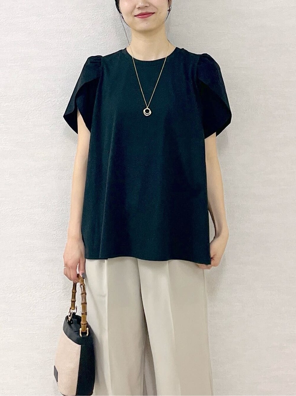 ブラック系のTシャツ/カットソー、ベージュ系のその他パンツ、ブラック系のショルダーバッグを着用したレディースの春コーディネートの7枚目の写真