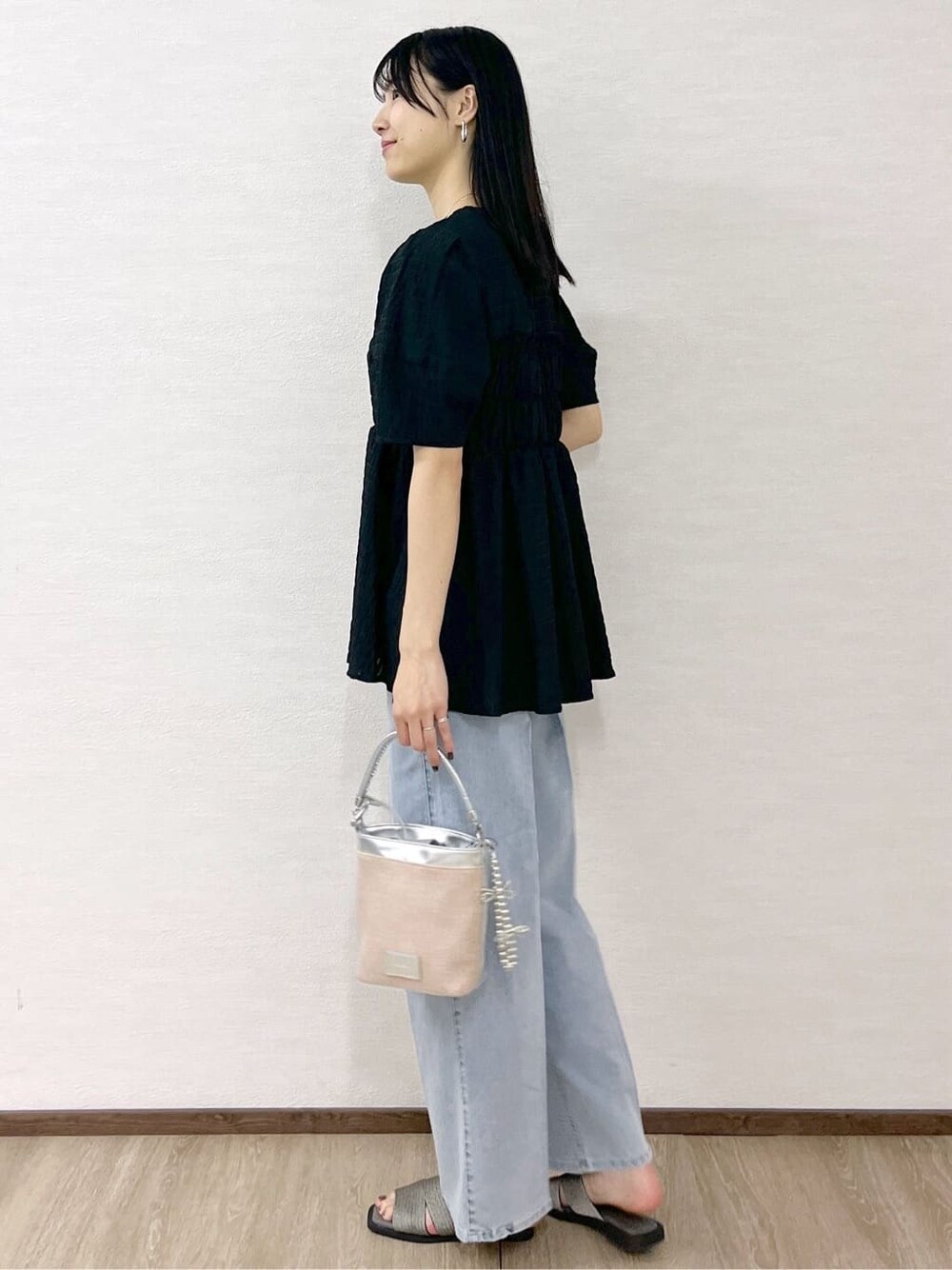 ブラック系のシャツ/ブラウス、ブルー系のデニムパンツ、シルバー系のショルダーバッグを着用したレディースの春コーディネートの5枚目の写真