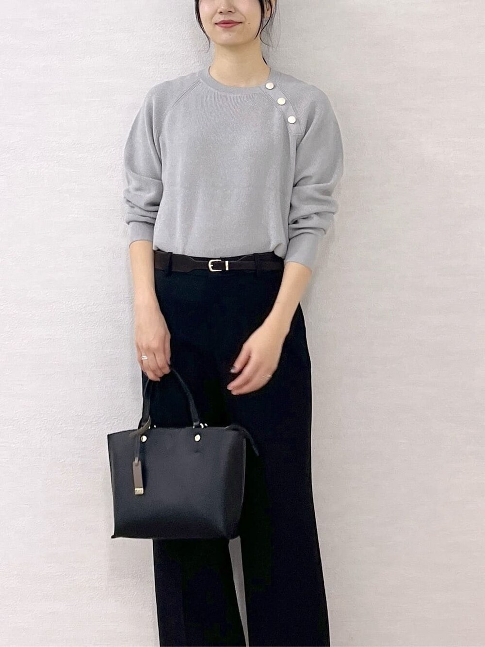 ブラック系のノーカラーコート、グレー系のニット/セーター、ブラック系のその他パンツを着用したレディースの秋コーディネートの9枚目の写真