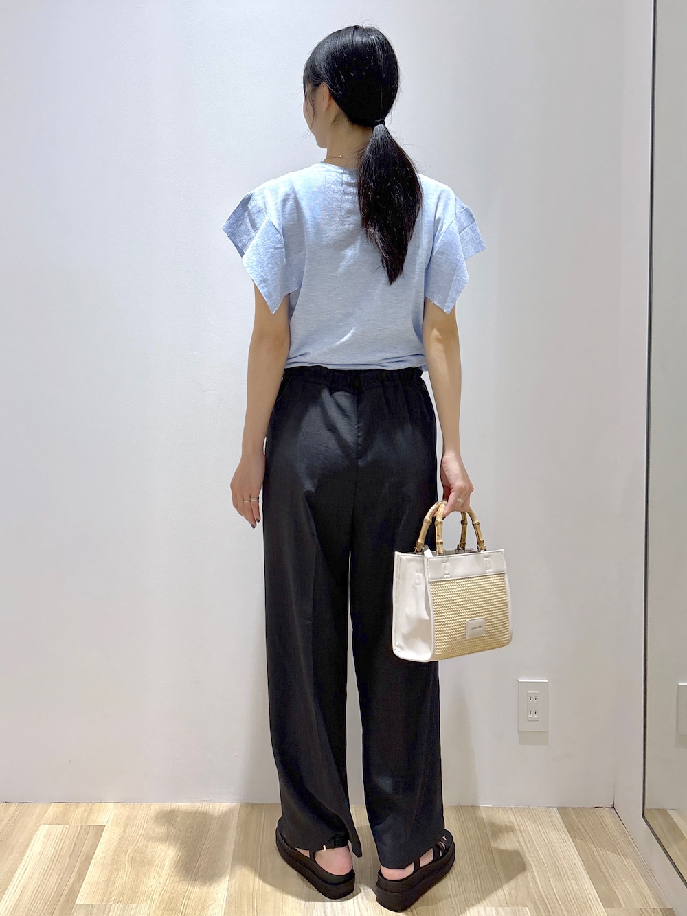 ブルー系のニット/セーター、グレー系のその他パンツ、ホワイト系のトートバッグを着用したレディースの夏コーディネートの4枚目の写真
