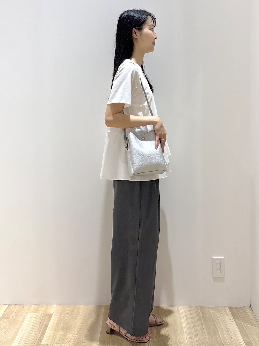 ホワイト系のTシャツ/カットソー、グレー系のその他パンツ、シルバー系のショルダーバッグを着用したレディースの夏コーディネートの4枚目の写真