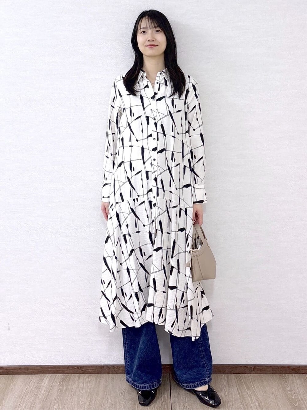 ベージュ系のワンピース、ブルー系のデニムパンツ、ベージュ系のショルダーバッグを着用したレディースの春コーディネートの9枚目の写真