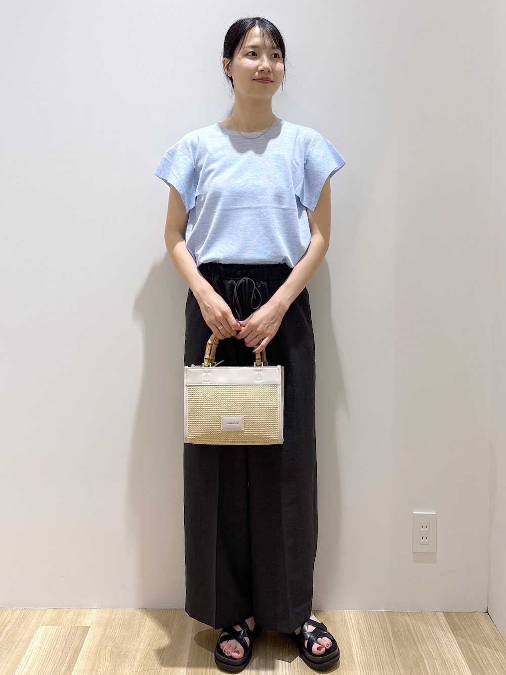 ブルー系のニット/セーター、グレー系のその他パンツ、ホワイト系のトートバッグを着用したレディースの夏コーディネートの9枚目の写真