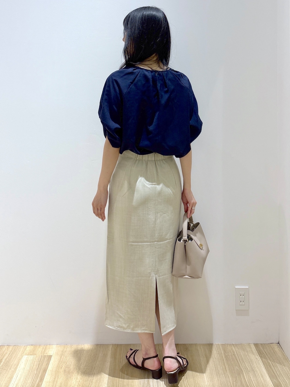 ブルー系のシャツ/ブラウス、ベージュ系のスカート、ベージュ系のハンドバッグを着用したレディースの夏コーディネートの4枚目の写真