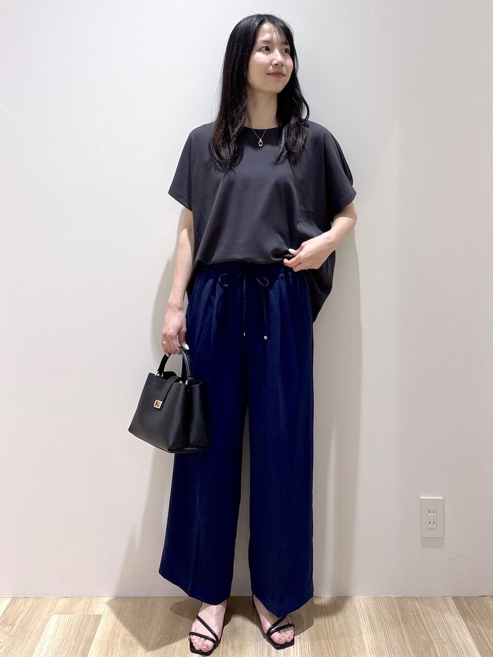 ブラック系のハンドバッグ、ベージュ系のショルダーバッグ、グレー系のTシャツ/カットソーを着用したレディースの春コーディネートの8枚目の写真