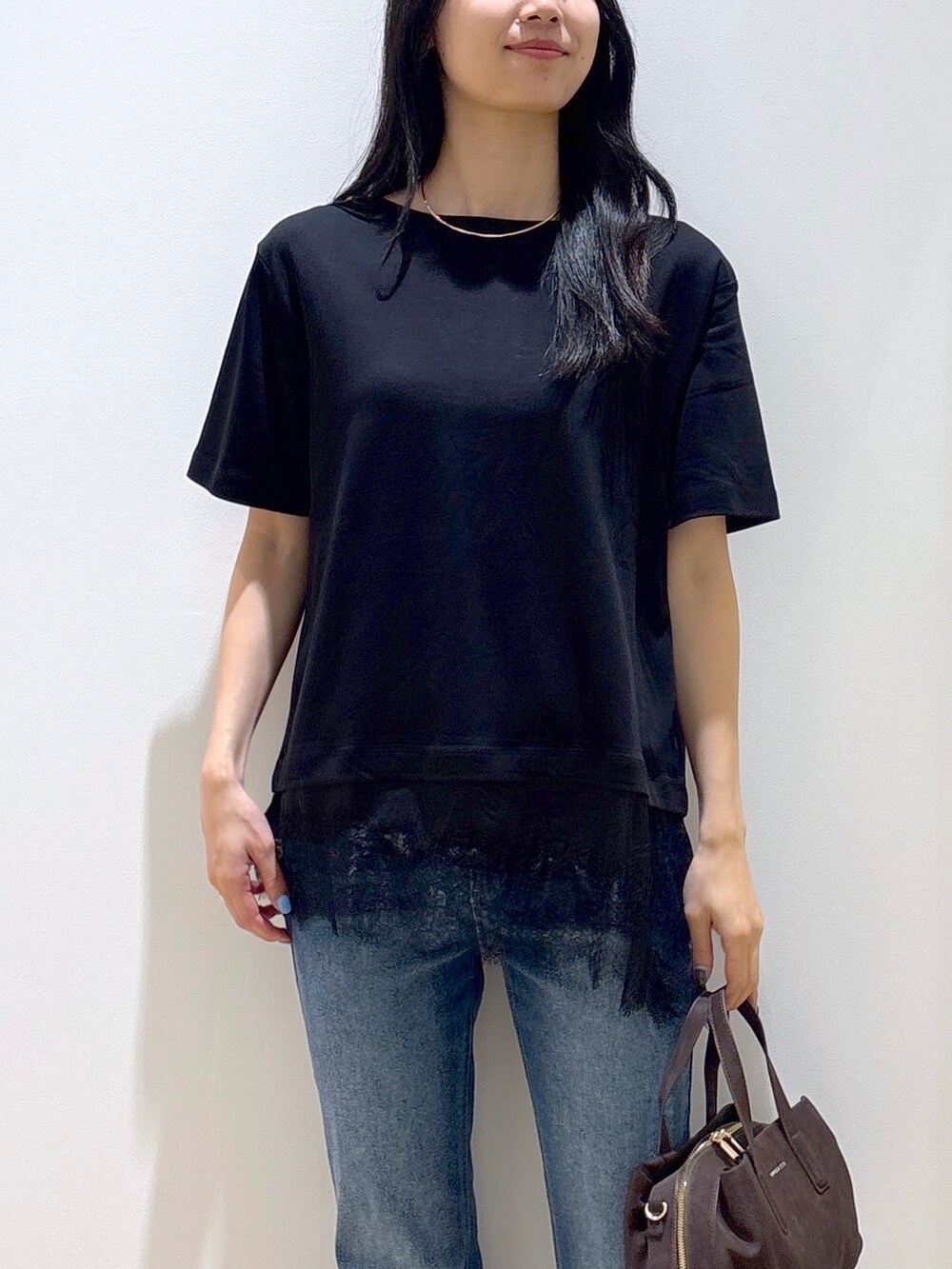 ブラック系のTシャツ/カットソー、ブルー系のデニムパンツ、ブラウン系のボストンバッグを着用したレディースの夏コーディネートの6枚目の写真