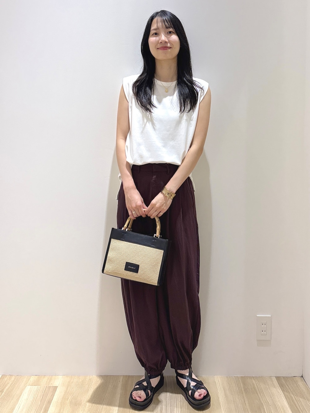 ホワイト系のTシャツ/カットソー、ブラウン系のその他パンツ、ブラック系のトートバッグを着用したレディースの夏コーディネートの2枚目の写真