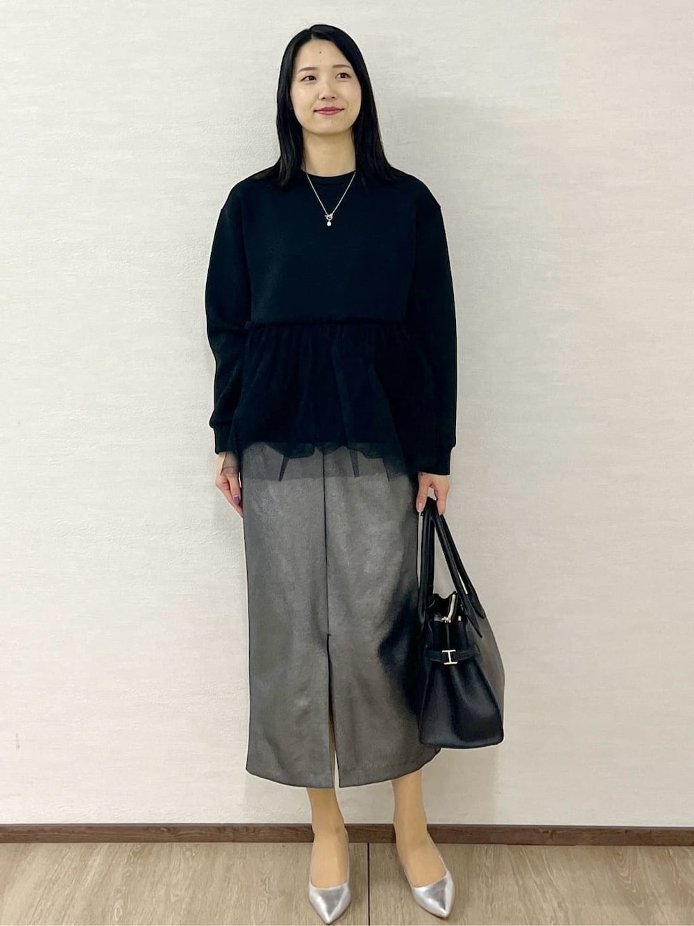 グレー系のノーカラーコート、ブラック系のTシャツ/カットソー、ブラック系のスカートを着用したレディースの冬コーディネートの7枚目の写真