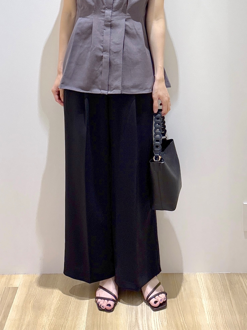 ブラック系のその他パンツ、ブラウン系のサンダル、ブラック系のショルダーバッグを着用したレディースの春コーディネートの7枚目の写真