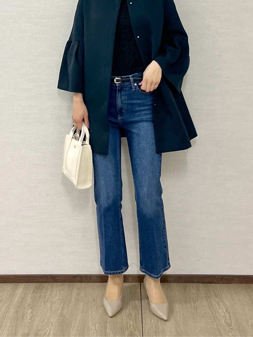 ブルー系のノーカラーコート、ブラック系のTシャツ/カットソー、ブルー系のデニムパンツを着用したレディースの冬コーディネートの8枚目の写真