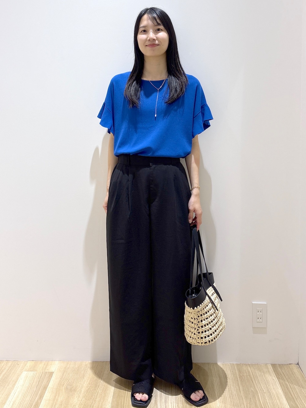 ブルー系のニット/セーター、ブラック系のその他パンツ、ブラック系のトートバッグを着用したレディースの夏コーディネートの8枚目の写真