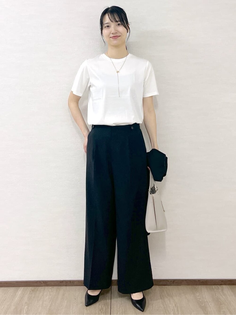 ホワイト系のTシャツ/カットソー、ブラック系のその他パンツ、ベージュ系のトートバッグを着用したレディースの夏コーディネートの2枚目の写真