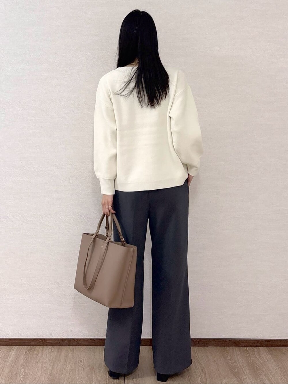 ホワイト系のニット/セーター、グレー系のその他パンツ、ベージュ系のトートバッグを着用したレディースの冬コーディネートの5枚目の写真