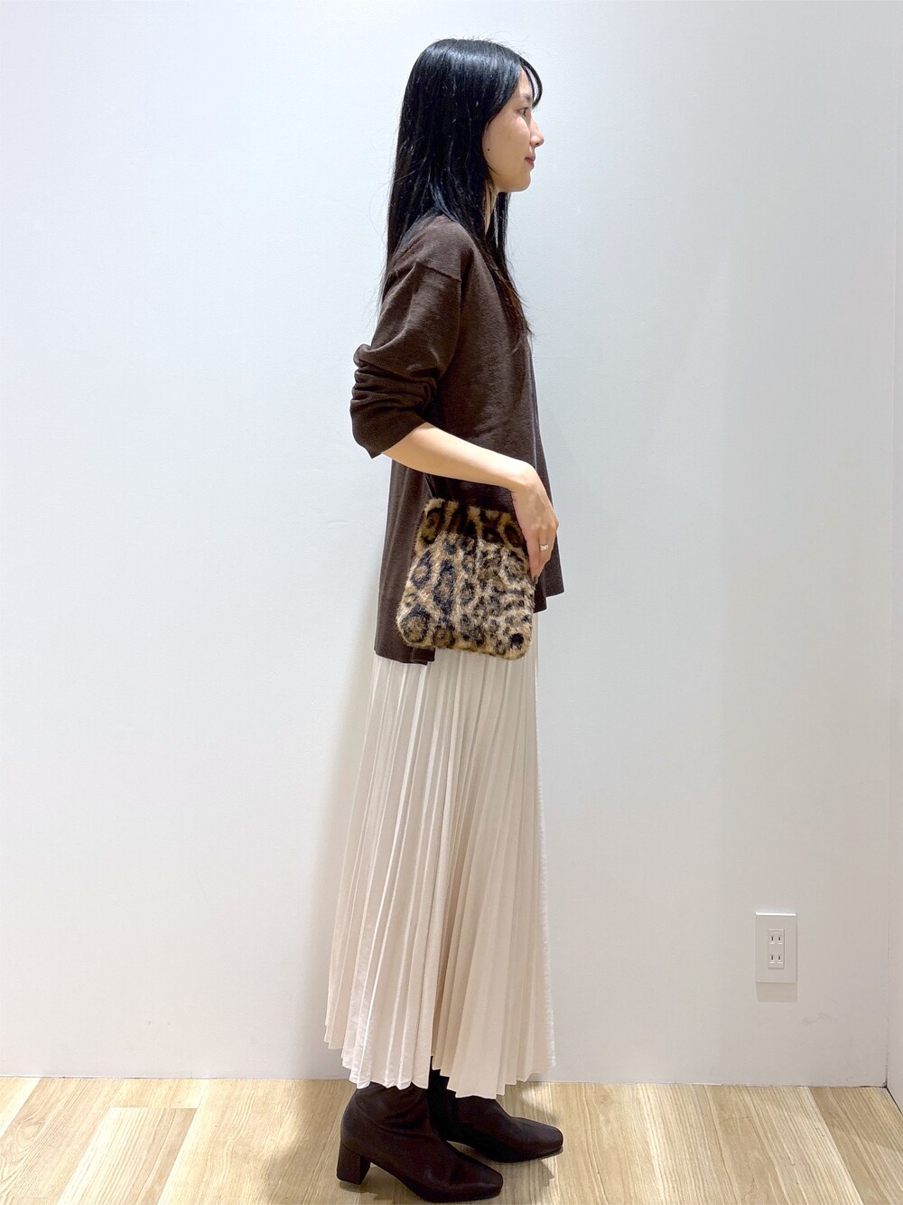 ブラウン系のニット/セーター、ホワイト系のスカート、ブラウン系のショルダーバッグを着用したレディースの秋コーディネートの5枚目の写真