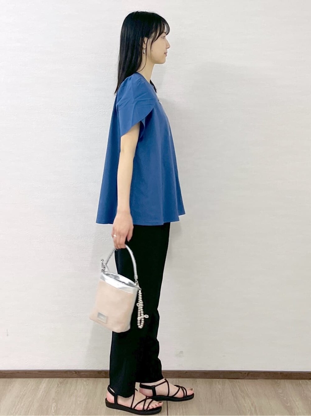 ブルー系のTシャツ/カットソー、ブラック系のその他パンツ、シルバー系のショルダーバッグを着用したレディースの春コーディネートの6枚目の写真