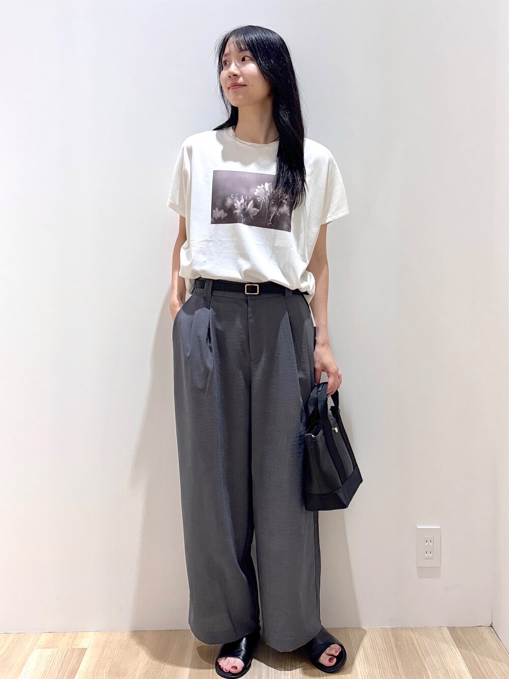 ホワイト系のTシャツ/カットソー、グレー系のその他パンツ、ブラック系のトートバッグを着用したレディースの夏コーディネートの2枚目の写真