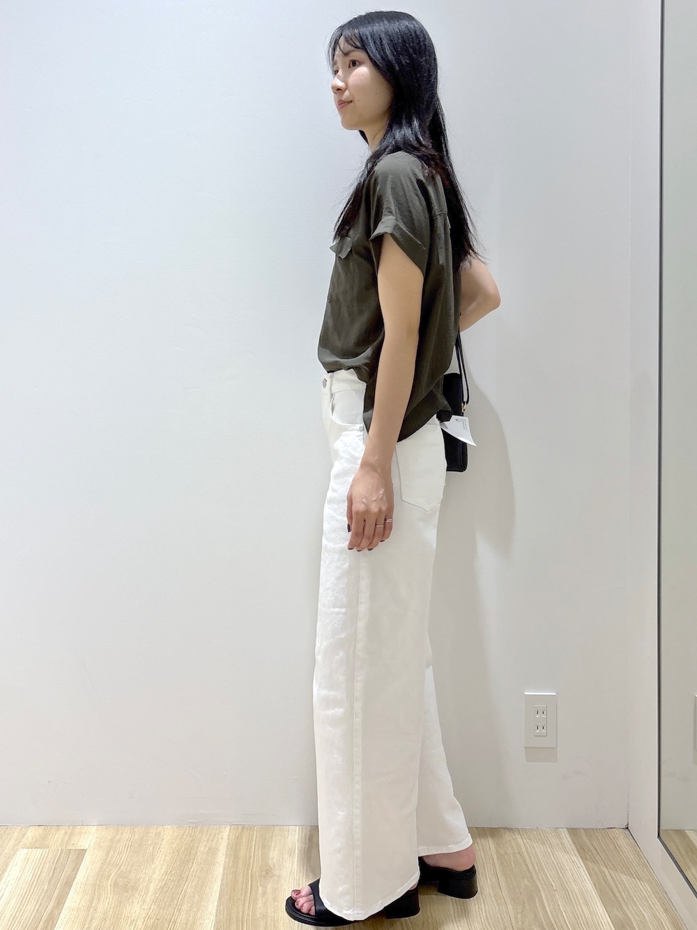 グリーン系のシャツ/ブラウス、ホワイト系のデニムパンツ、ブラック系のショルダーバッグを着用したレディースの夏コーディネートの3枚目の写真