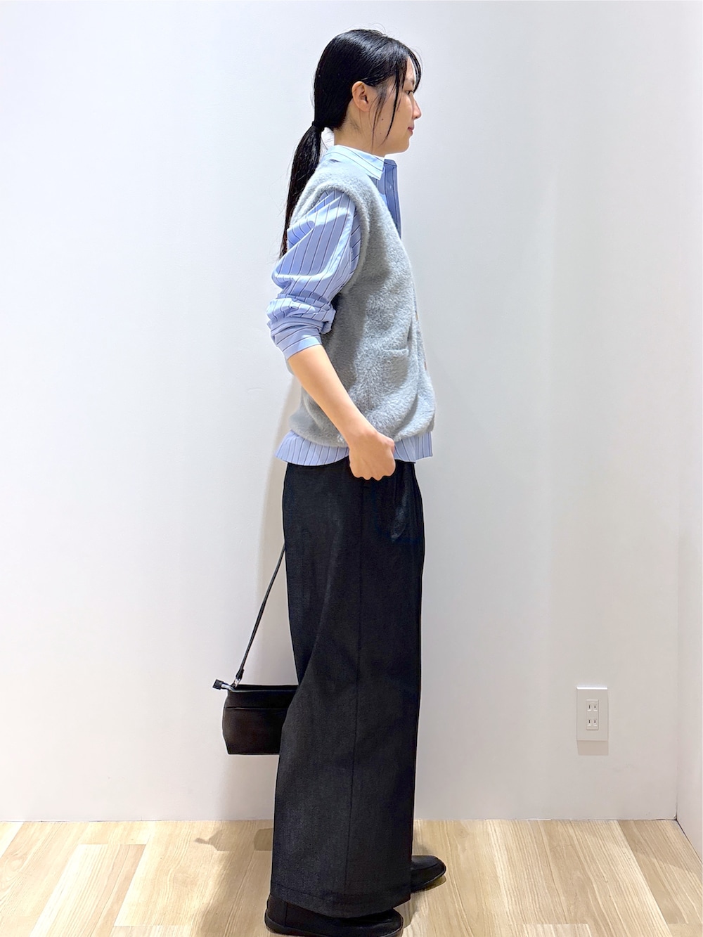 グレー系のニット/セーター、ブラック系のその他パンツ、ブラック系のショルダーバッグを着用したレディースの秋コーディネートの5枚目の写真