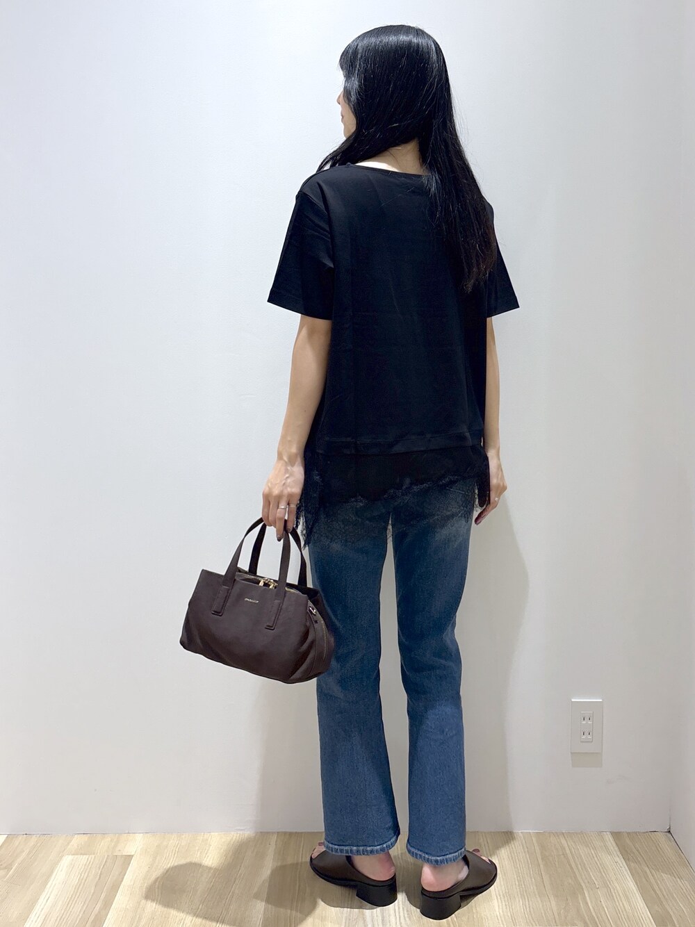 ブラック系のTシャツ/カットソー、ブルー系のデニムパンツ、ブラウン系のボストンバッグを着用したレディースの夏コーディネートの4枚目の写真