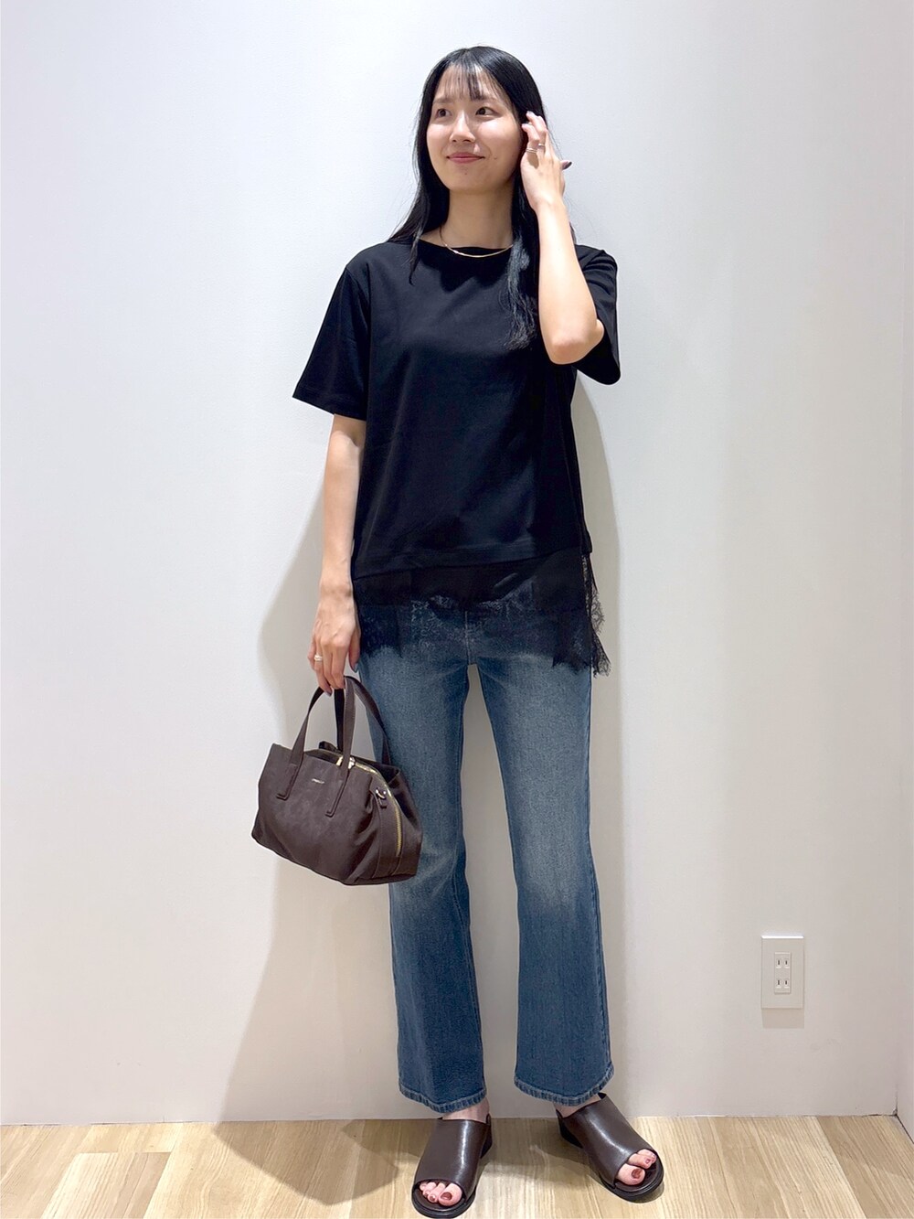 ブラック系のTシャツ/カットソー、ブルー系のデニムパンツ、ブラウン系のボストンバッグを着用したレディースの夏コーディネートの9枚目の写真