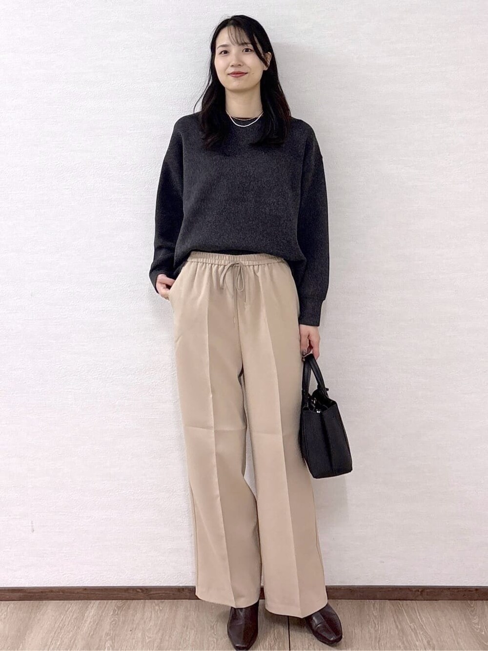 グレー系のニット/セーター、ベージュ系のその他パンツ、ブラック系のトートバッグを着用したレディースの冬コーディネートの8枚目の写真
