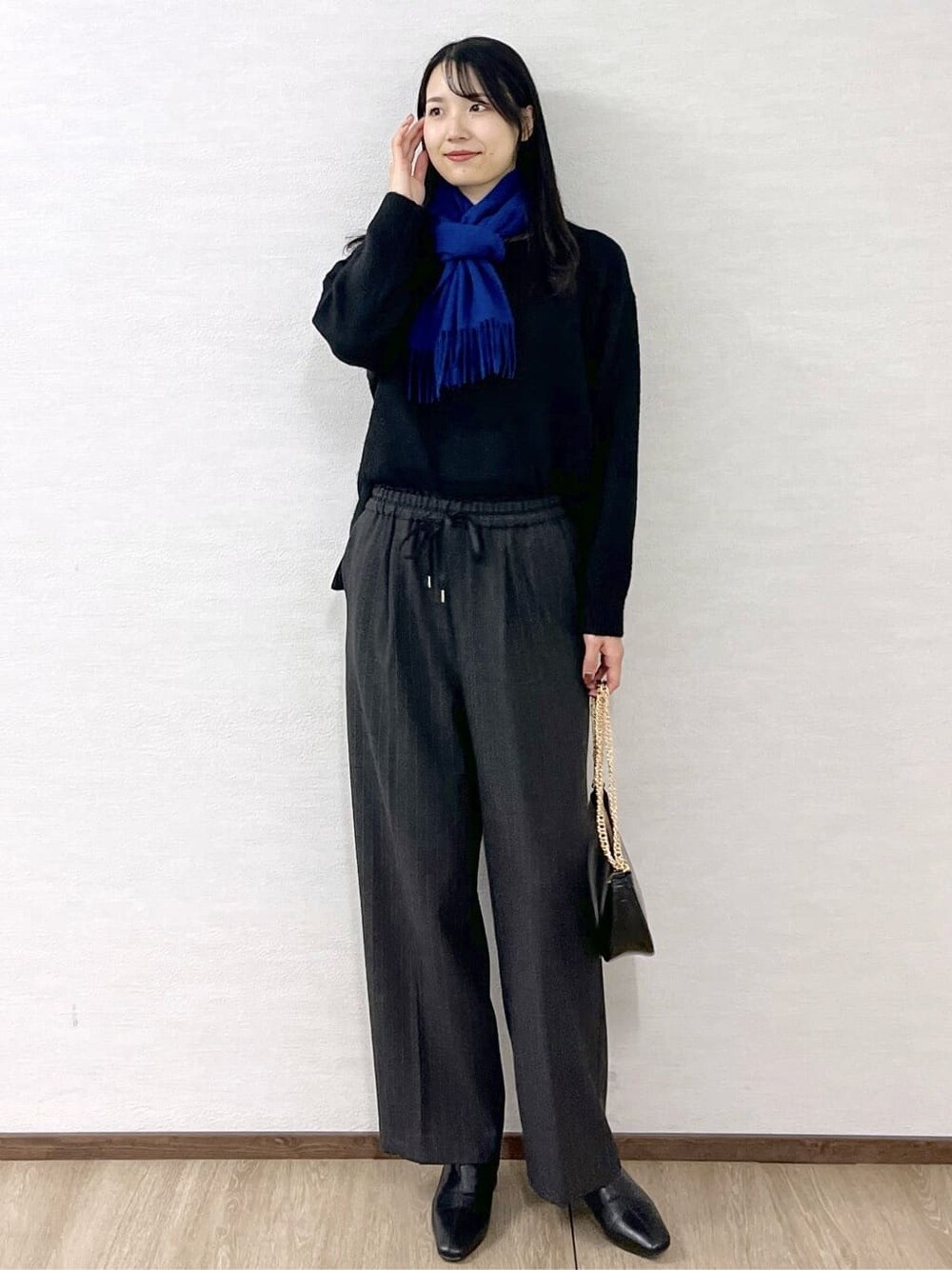 ブラック系のニット/セーター、グレー系のその他パンツ、ブラック系のハンドバッグを着用したレディースの冬コーディネートの10枚目の写真