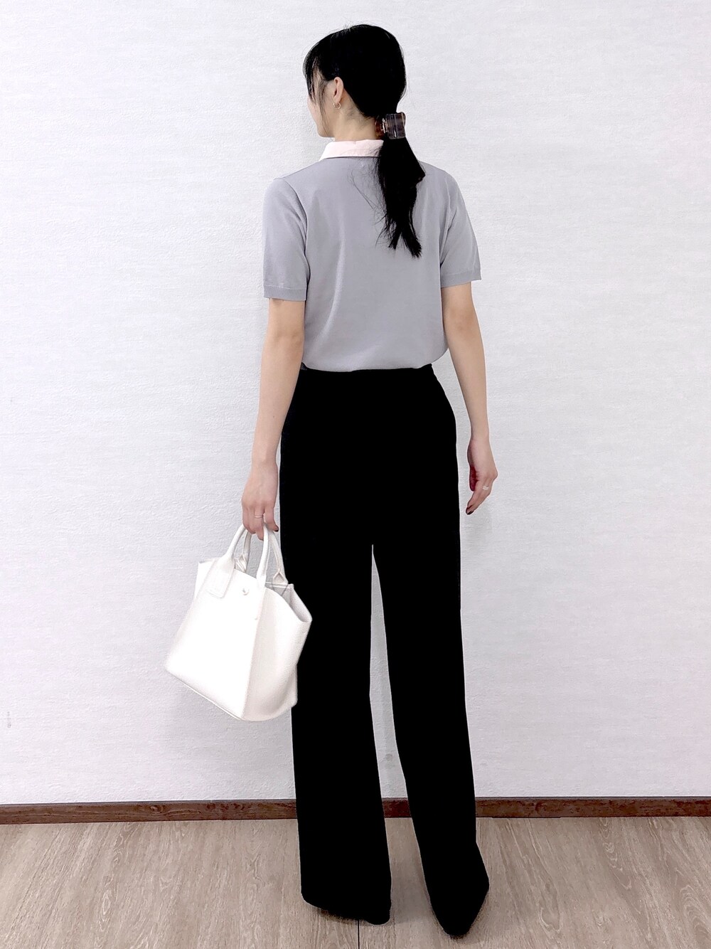 ホワイト系のショルダーバッグ、ブラック系のパンプス、ベージュ系のトートバッグを着用したレディースの春コーディネートの4枚目の写真